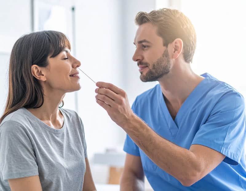 Logo-Etre-soi Infirmier présentant une touche à sentir à un patient souriant dans un cadre de soin bienveillant